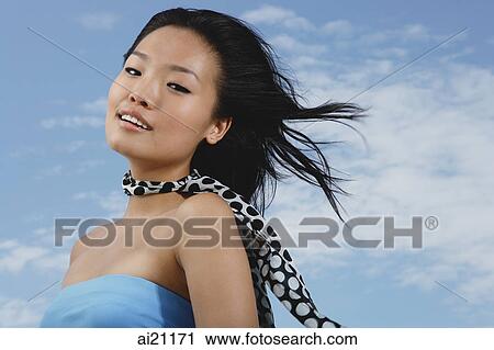 Woman in blue tube top, scarf around her neck, smiling at camera View Large Photo Image Stock Image - Woman in blue tube top, scarf around her neck, smiling at camera. Fotosearch