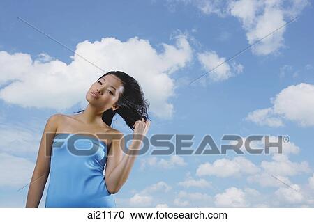 Woman in blue tube top, standing against blue sky View Large Photo Image Stock Image - Woman in blue tube top, standing against blue sky. Fotosearch