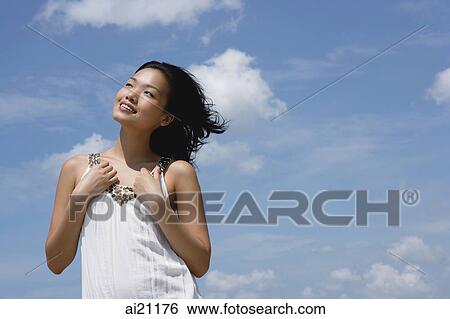 Woman in white top, smiling, looking away View Large Photo Image Stock Photograph - Woman in white top, smiling, looking away. Fotosearch