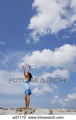 Woman standing on breakwater, holding balloons in air View Large Photo Image Stock Image - Woman standing on breakwater, holding balloons in air. Fotosearch