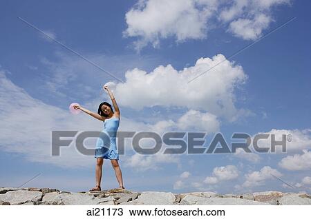 Woman standing on breakwater, waving balloons in air View Large Photo Image Stock Image - Woman standing on breakwater, waving balloons in air. Fotosearch