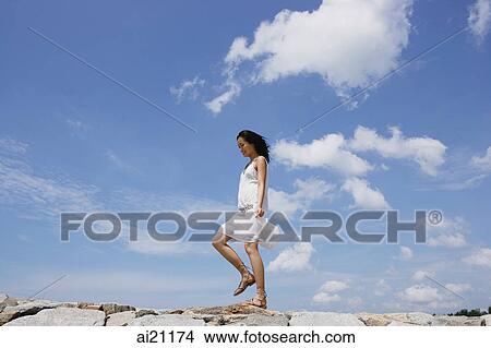 Woman walking on breakwater View Large Photo Image Picture - Woman walking on breakwater. Fotosearch
