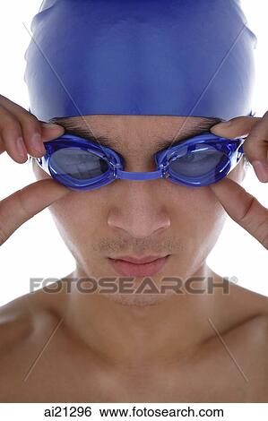 Stock Photograph - Young man adjusting swimming goggles. Fotosearch
