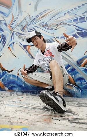 Young man in front of graffiti covered wall View Large Photo Image Stock Photo - Young man in front of graffiti covered wall. Fotosearch