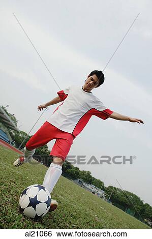 Young man kicking soccer ball View Large Photo Image Stock Photograph - Young man kicking soccer ball. Fotosearch