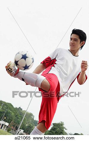 Young man kicking soccer ball View Large Photo Image Stock Photography - Young man kicking soccer ball. Fotosearch