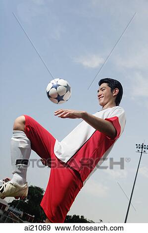 Young man playing with soccer ball, keeping ball up View Large Photo Image Stock Photo - Young man playing with soccer ball, keeping ball up. Fotosearch