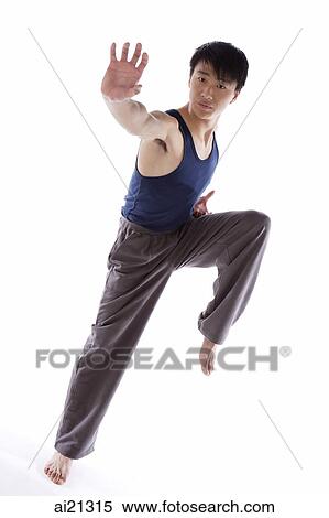 Stock Photography - Young man practicing kong fu, balancing on one leg. Fotosearch