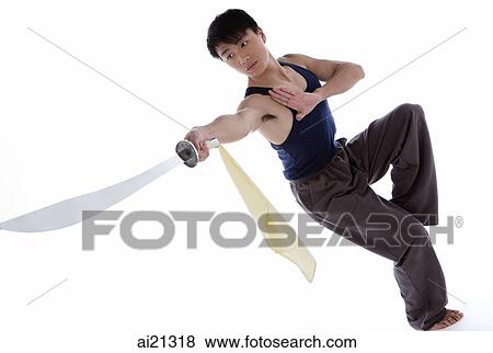 Young man practicing martial arts, holding sword View Large Photo Image Stock Photo - Young man practicing martial arts, holding sword. Fotosearch