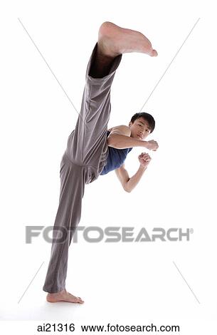 Young man practicing martial arts, kicking View Large Photo Image Stock Photograph - Young man practicing martial arts, kicking. Fotosearch