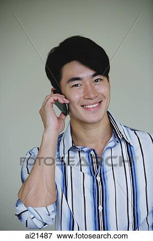Young man using mobile phone View Large Photo Image Stock Photo - Young man using mobile phone. Fotosearch