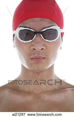 Young man wearing swimming goggles and swimming cap, face wet View Large Photo Image Stock Photo - Young man wearing swimming goggles and swimming cap, face wet. Fotosearch