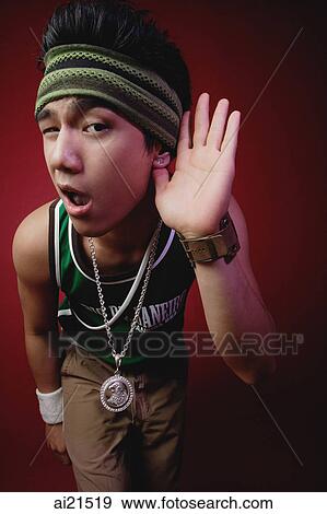 Young man with sweat band, holding hand to ear View Large Photo Image Stock Photo - Young man with sweat band, holding hand to ear. Fotosearch