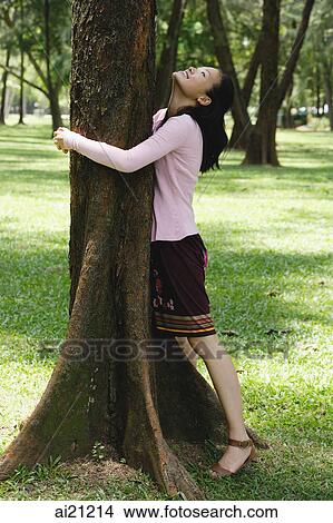 Young woman hugging a tree View Large Photo Image Picture - Young woman hugging a tree. Fotosearch