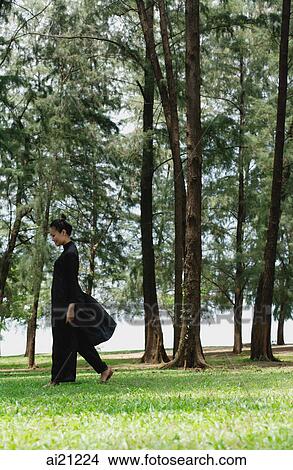 Young woman in traditional Chinese costume, walking amongst trees View Large Photo Image Picture - Young woman in traditional Chinese costume, walking amongst trees. Fotosearch