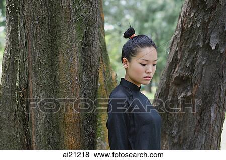 Stock Photo - Young woman in traditional Chinese costume, outdoors. Fotosearch