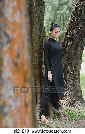 Young woman in traditional Chinese costume, standing amongst trees View Large Photo Image Stock Photo - Young woman in traditional Chinese costume, standing amongst trees. Fotosearch
