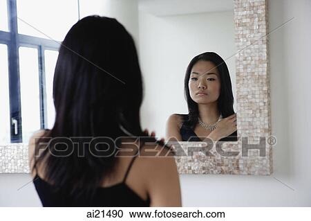 Young woman looking in mirror View Large Photo Image Stock Image - Young woman looking in mirror. Fotosearch