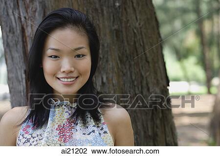 Young woman outdoors, smiling at camera View Large Photo Image Stock Image - Young woman outdoors, smiling at camera. Fotosearch