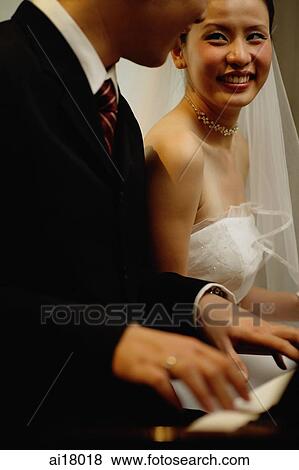Bride and Groom, sitting side by side playing the piano View Large Photo Image Stock Photo - Bride and Groom, sitting side by side playing the piano. Fotosearch