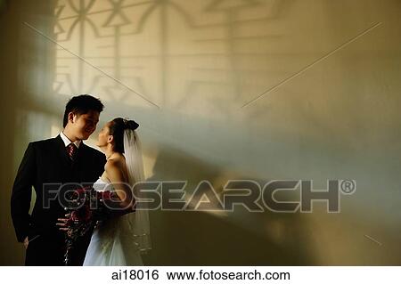 Bride and Groom, standing side by side looking at each other View Large Photo Image Stock Photograph - Bride and Groom, standing side by side looking at each other. Fotosearch