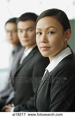Business people seating in a row, looking at camera, focus on the woman View Large Photo Image Stock Photo - Business people seating in a row, looking at camera, focus on the woman. Fotosearch