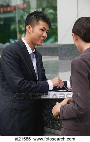 Businessman and businesswoman having a discussion View Large Photo Image Stock Photograph - Businessman and businesswoman having a discussion. Fotosearch
