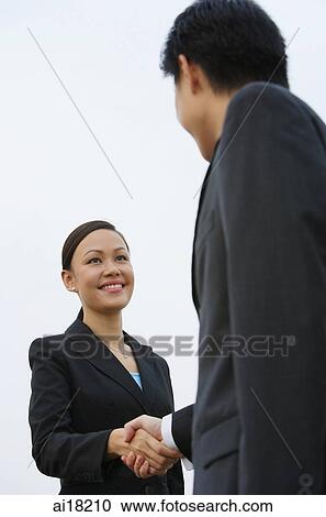 Businessman and businesswoman shaking hands, low angle view View Large Photo Image Stock Image - Businessman and businesswoman shaking hands, low angle view. Fotosearch