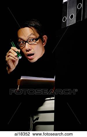 Businessman in office at night, looking at documents with flashlight, shocked expression View Large Photo Image Stock Image - Businessman in office at night, looking at documents with flashlight, shocked expression. Fotosearch
