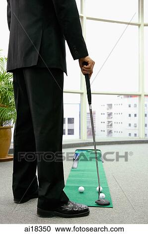 Businessman in office playing golf, low section View Large Photo Image Stock Image - Businessman in office playing golf, low section. Fotosearch