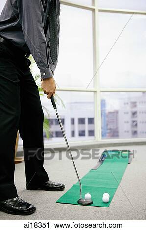 Businessman in office playing golf, aiming, low section View Large Photo Image Stock Image - Businessman in office playing golf, aiming, low section. Fotosearch