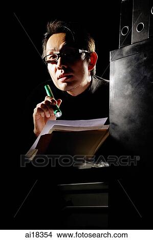 Businessman in the dark, holding flashlight and documents View Large Photo Image Picture - Businessman in the dark, holding flashlight and documents. Fotosearch