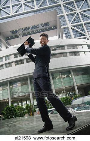 Businessman lifting briefcase in air, smiling at camera View Large Photo Image Stock Photo - Businessman lifting briefcase in air, smiling at camera. Fotosearch
