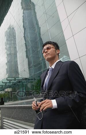 Businessman listening to MP3 player View Large Photo Image Stock Image - Businessman listening to MP3 player. Fotosearch