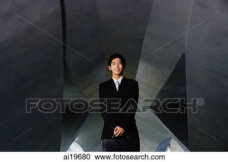 Businessman looking at camera, holding briefcase View Large Photo Image Stock Image - Businessman looking at camera, holding briefcase. Fotosearch