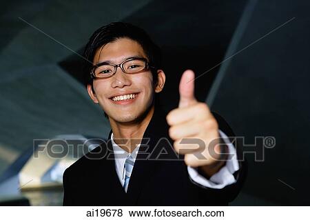 Businessman looking at camera, making a thumbs up sign View Large Photo Image Stock Photo - Businessman looking at camera, making a thumbs up sign. Fotosearch