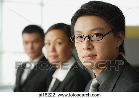 Businessman looking at camera, people in a row behind him View Large Photo Image Stock Image - Businessman looking at camera, people in a row behind him. Fotosearch