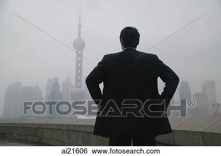 Businessman looking at Oriental Pearl TV Tower in the background View Large Photo Image Stock Photograph - Businessman looking at Oriental Pearl TV Tower in the background. Fotosearch