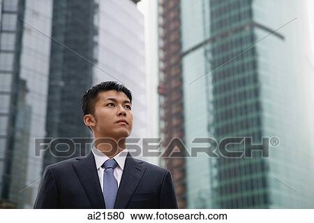 Businessman looking away, buildings in the background View Large Photo Image Stock Image - Businessman looking away, buildings in the background. Fotosearch