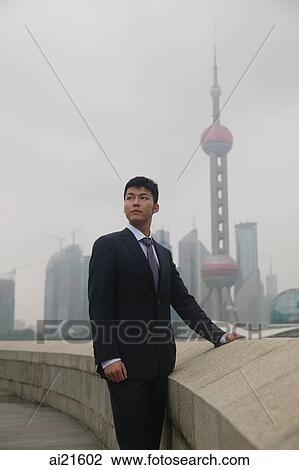 Stock Image - Businessman looking away, Oriental Pearl TV Tower in the background. Fotosearch