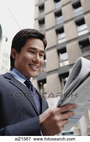Businessman reading newspaper, city location View Large Photo Image Stock Photo - Businessman reading newspaper, city location. Fotosearch
