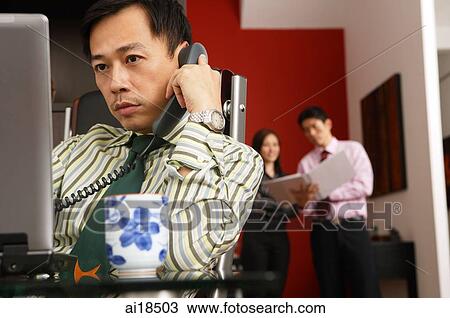 Businessman sitting in front on computer monitor, people in the background View Large Photo Image Stock Image - Businessman sitting in front on computer monitor, people in the background. Fotosearch