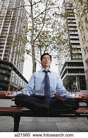 Businessman sitting in the city, meditating View Large Photo Image Stock Image - Businessman sitting in the city, meditating. Fotosearch