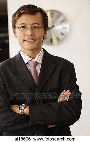 Businessman smiling at camera, arms crossed View Large Photo Image Stock Photograph - Businessman smiling at camera, arms crossed. Fotosearch