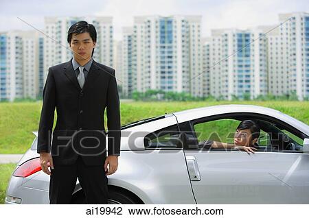 Businessman standing next to sports car, woman in car, looking out the car window View Large Photo Image Stock Image - Businessman standing next to sports car, woman in car, looking out the car window. Fotosearch