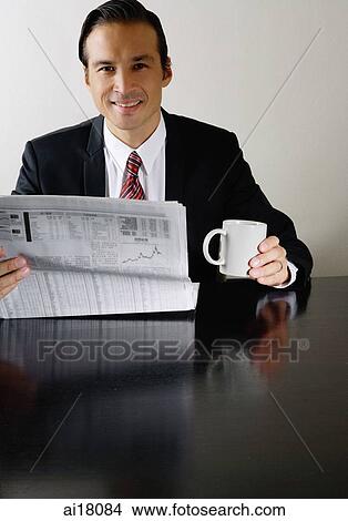 Businessman with newspaper and mug, smiling at camera View Large Photo Image Picture - Businessman with newspaper and mug, smiling at camera. Fotosearch