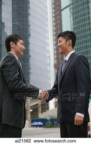Businessmen in the city, shaking hands View Large Photo Image Stock Image - Businessmen in the city, shaking hands. Fotosearch