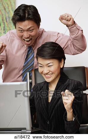 Businesspeople with excited expressions, looking at computer monitor View Large Photo Image Stock Image - Businesspeople with excited expressions, looking at computer monitor. Fotosearch