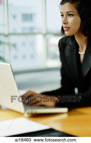 Businesswoman dressed in black, using laptop, looking away View Large Photo Image Stock Image - Businesswoman dressed in black, using laptop, looking away. Fotosearch