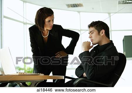 Stock Photograph - Businesswoman having a serious discussion with businessman. Fotosearch